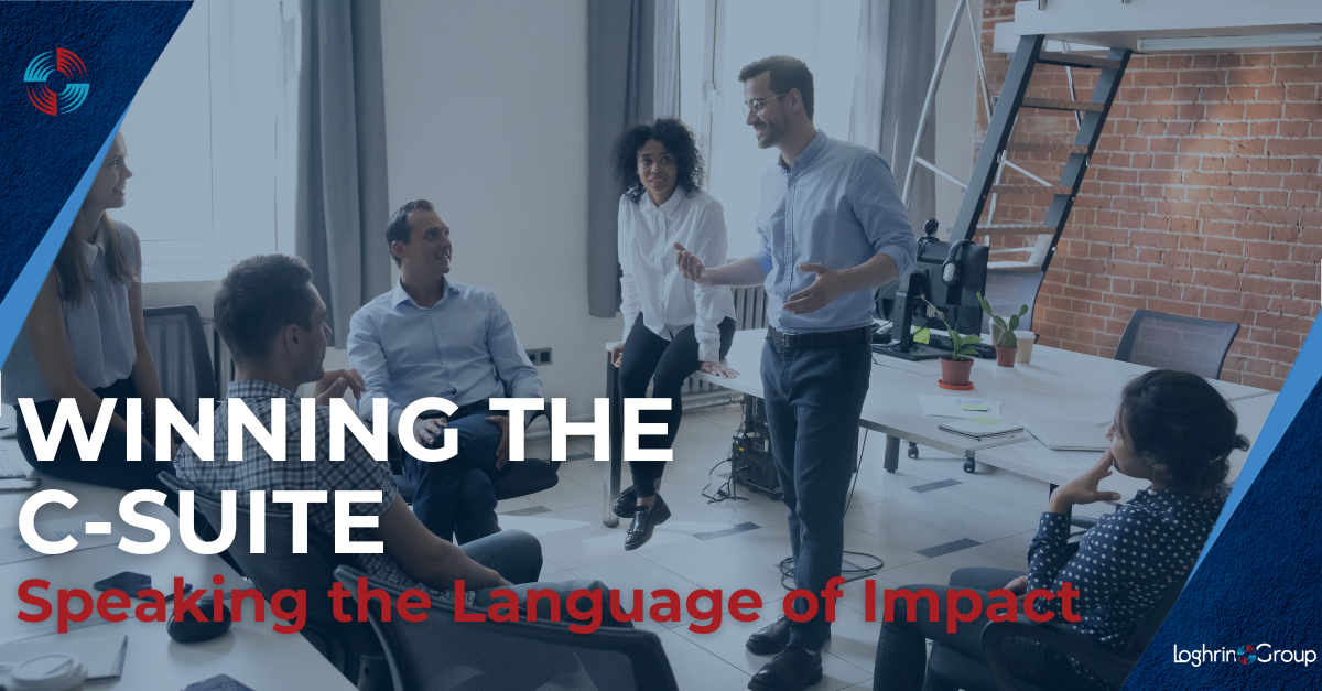 A group of professionals sit and stand in a modern office, engaged in discussion as one man presents while smiling. Bold text overlay reads: “Winning the C-Suite – Speaking the Language of Impact.” The Loghrin Group logo appears in the bottom right corner.